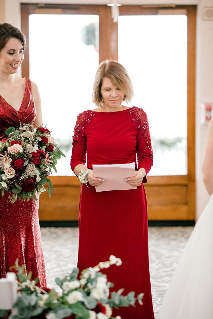 Woman wearing Red dress speaks at a Christmas Wedding 