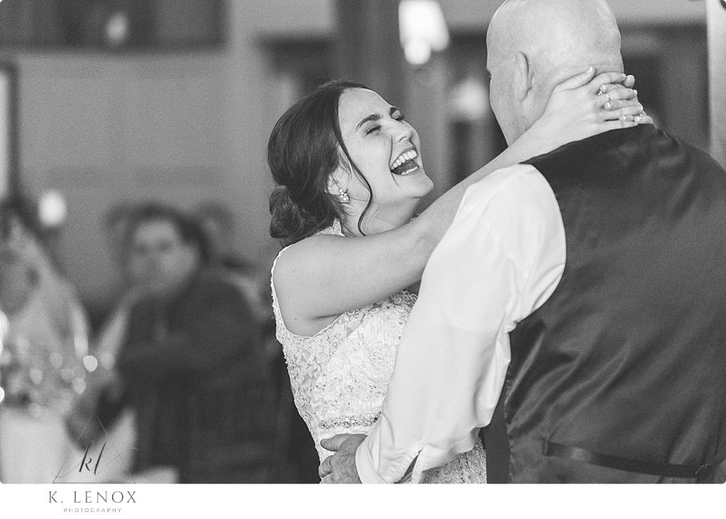 Daughter (bride) and father laugh and dance at the Barn at Gibbet Hill. 