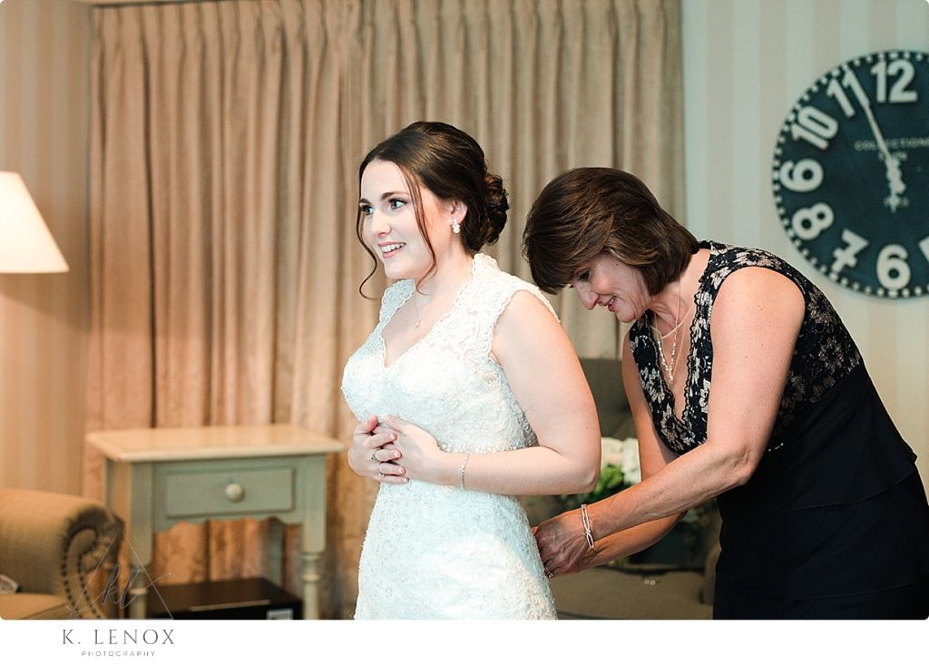 Mom helping the bride get into her dress in the bridal suite at the Barn at Gibbet Hill in Groton Ma. 
