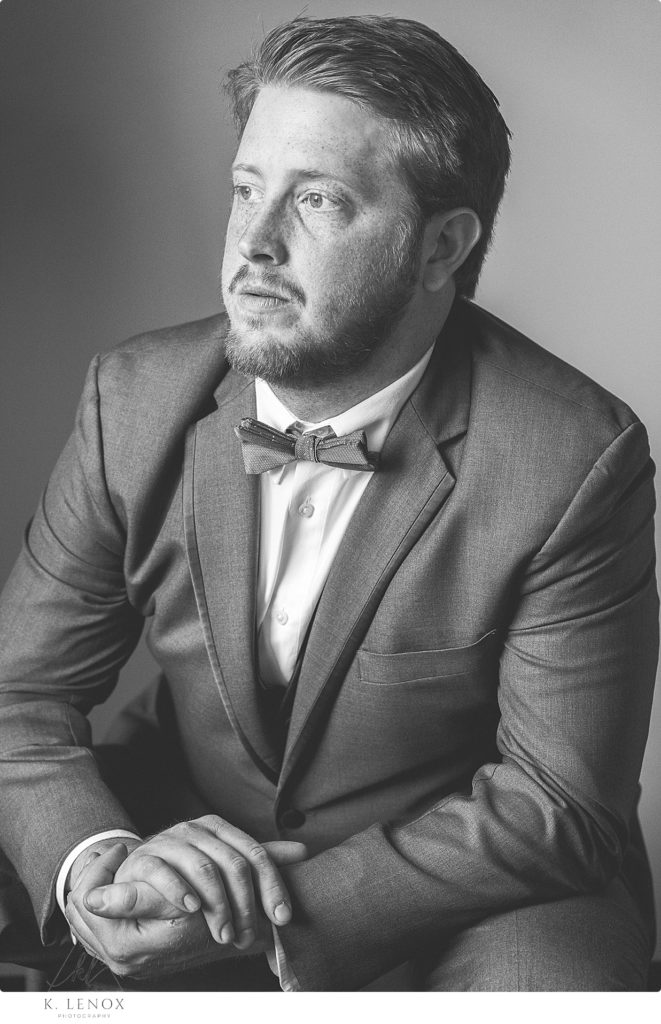 Black and White Portrait of a groom on his wedding day- wearing a gray suit and bowtie. 