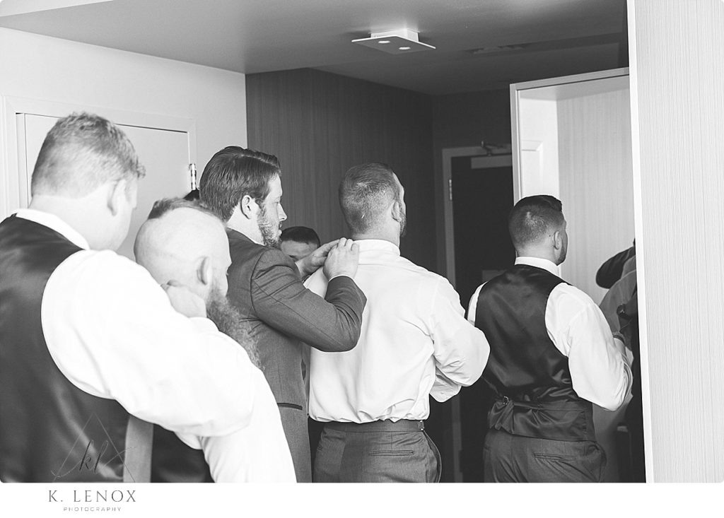 Candid black and white photo of a groom getting ready with the groomsmen at the Marriott. 