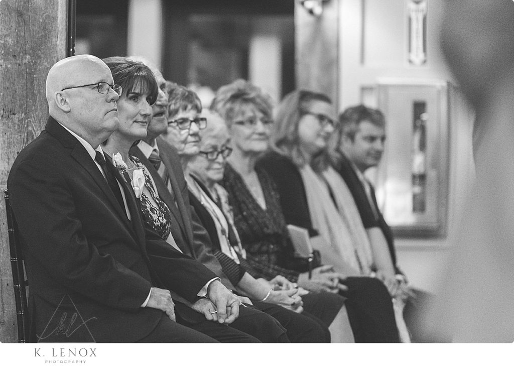 Black and White candid photo of parents watching their daughter get married. 
