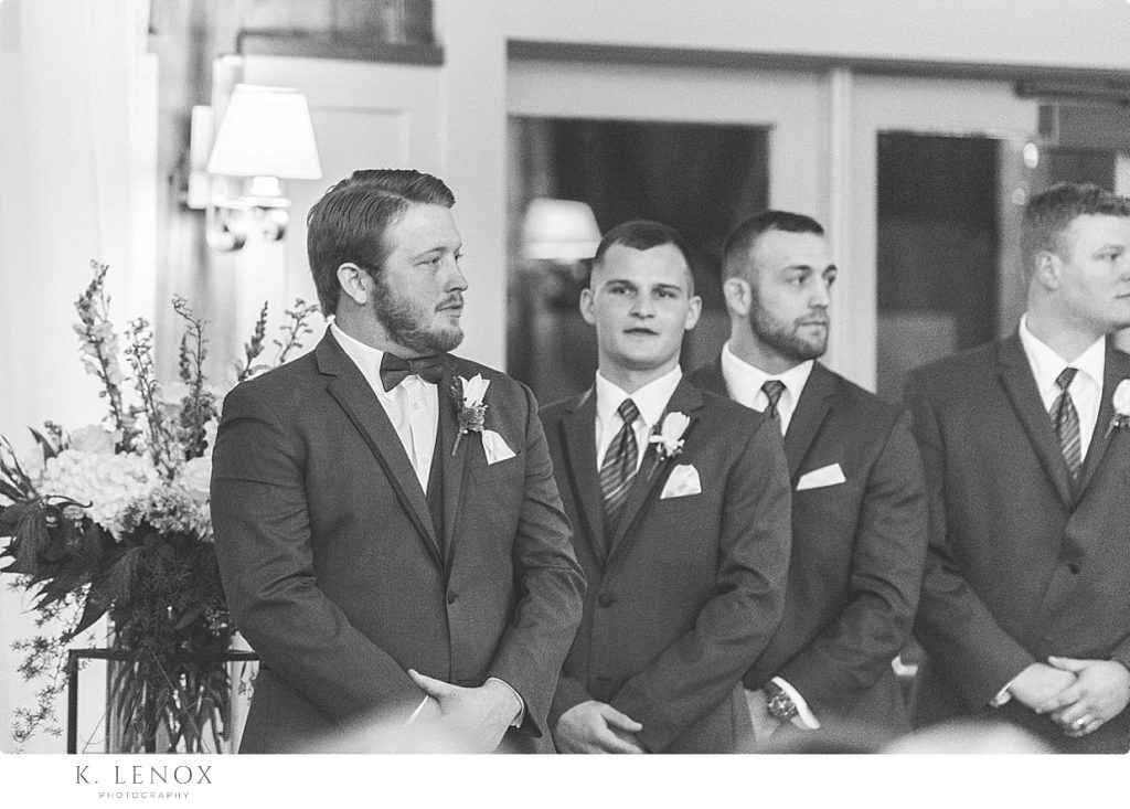 Candid, Black and White photo of a groom waiting for his bride to walk down the aisle at the Barn at Gibbet Hill. 