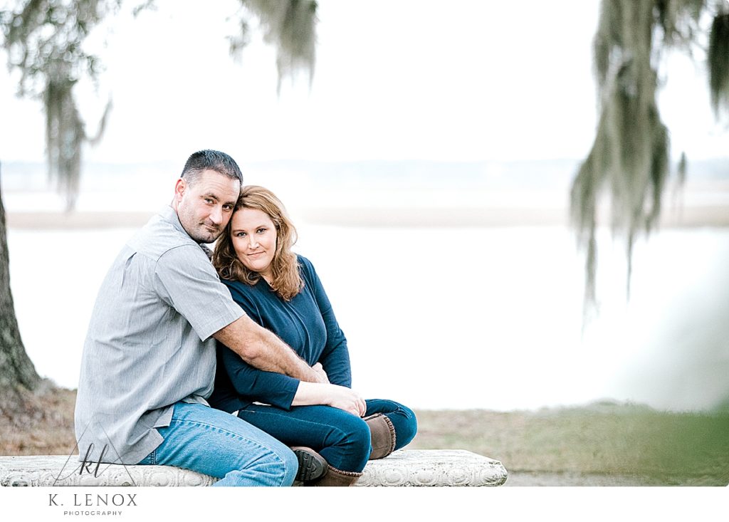 Portrait of a Man and woman sitting on a stone bench at Kate Gleason Park in Beaufort SC. Light and Airy photo by K. Lenox Photography