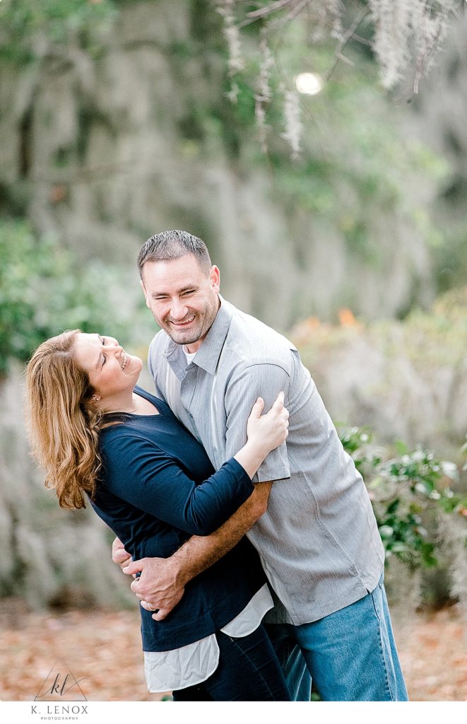 Man and woman laugh while their arms are around each other while in Beaufort SC during a photo session with K. Lenox Photography