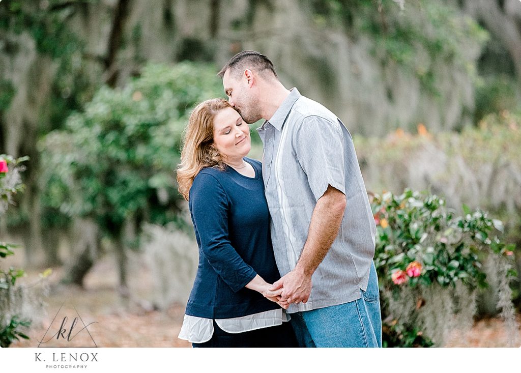 Man wearing Gray t-shirt kisses his wife during a couples portrait session in Beaufort SC. 