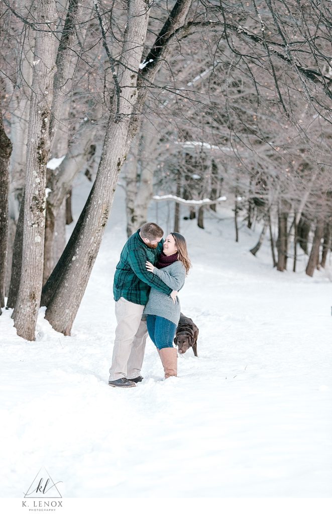 Man and Woman hugging during their winter engagement session in Peterborough NH