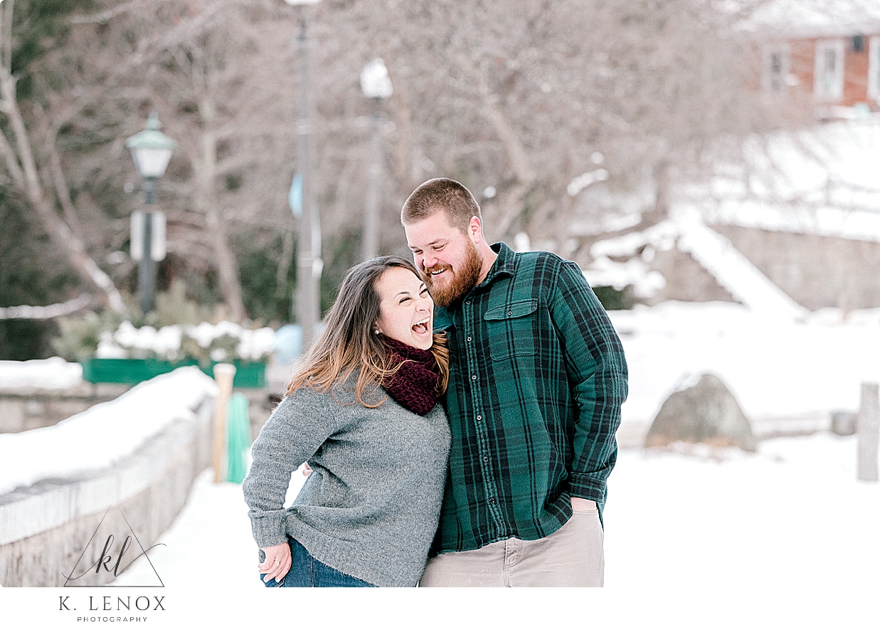 Engaged couple laugh and play during their winter engagement session. Image by K. Lenox photography