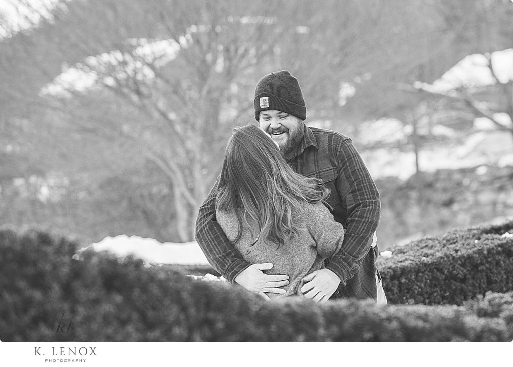 Black and White photo showing a candid and natural interaction between a man and woman.  Carhartt hat worn. 