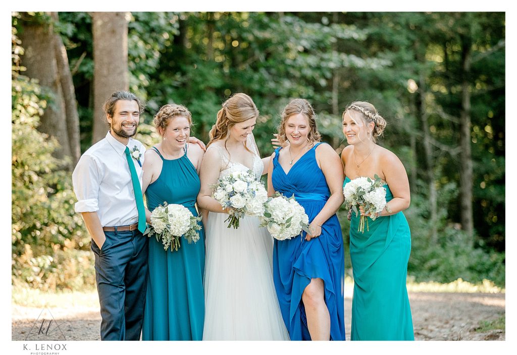 Wedding Party showing the Bride and three bridesmaids wearing different shades of blue dresses.   And a man wearing a white shirt and a blue tie.  Ways you can help your friend organize a wedding. 