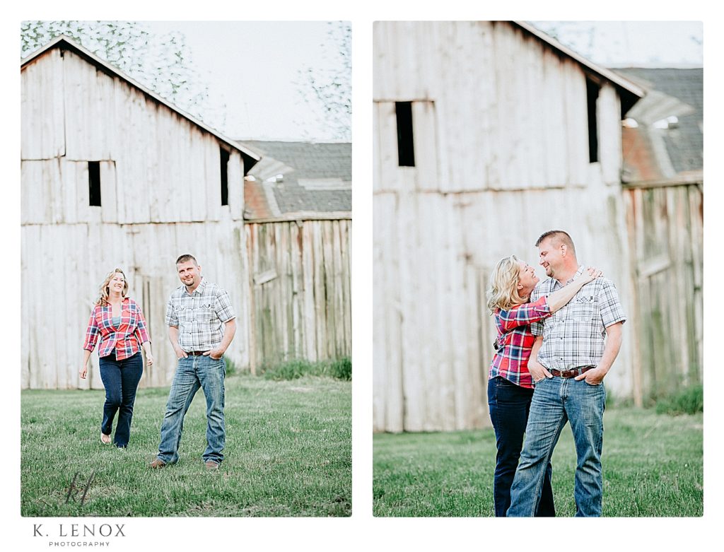 Light and Airy engagement photos of a couple wearing plaid shirts standing in front of a barn. 