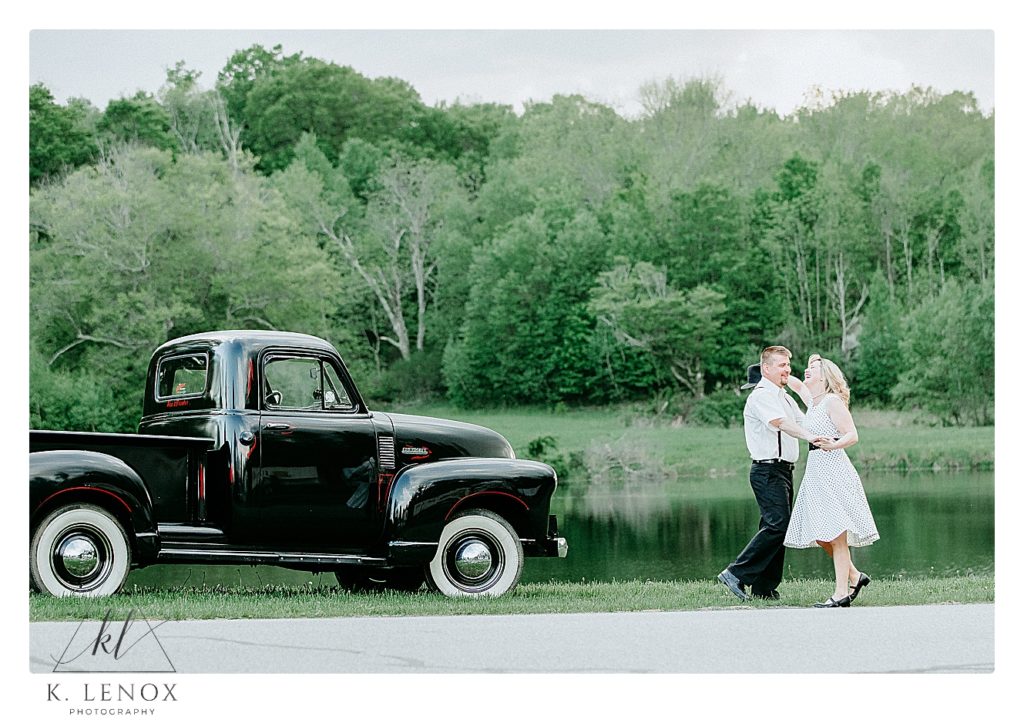 Man and Woman dance in front of a 1952 Chevy Truck during their engagement session in PA.  K. Lenox Photography