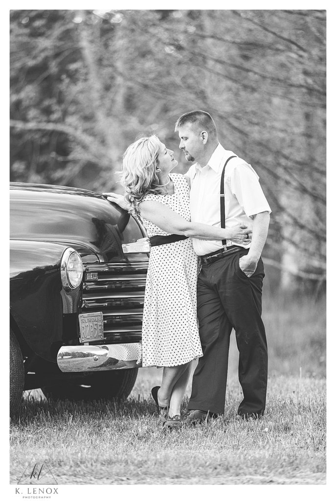 Black and White photo of a couple standing in front of a black 1952 Chevy Truck during their engagement session with  K. Lenox Photography. 
