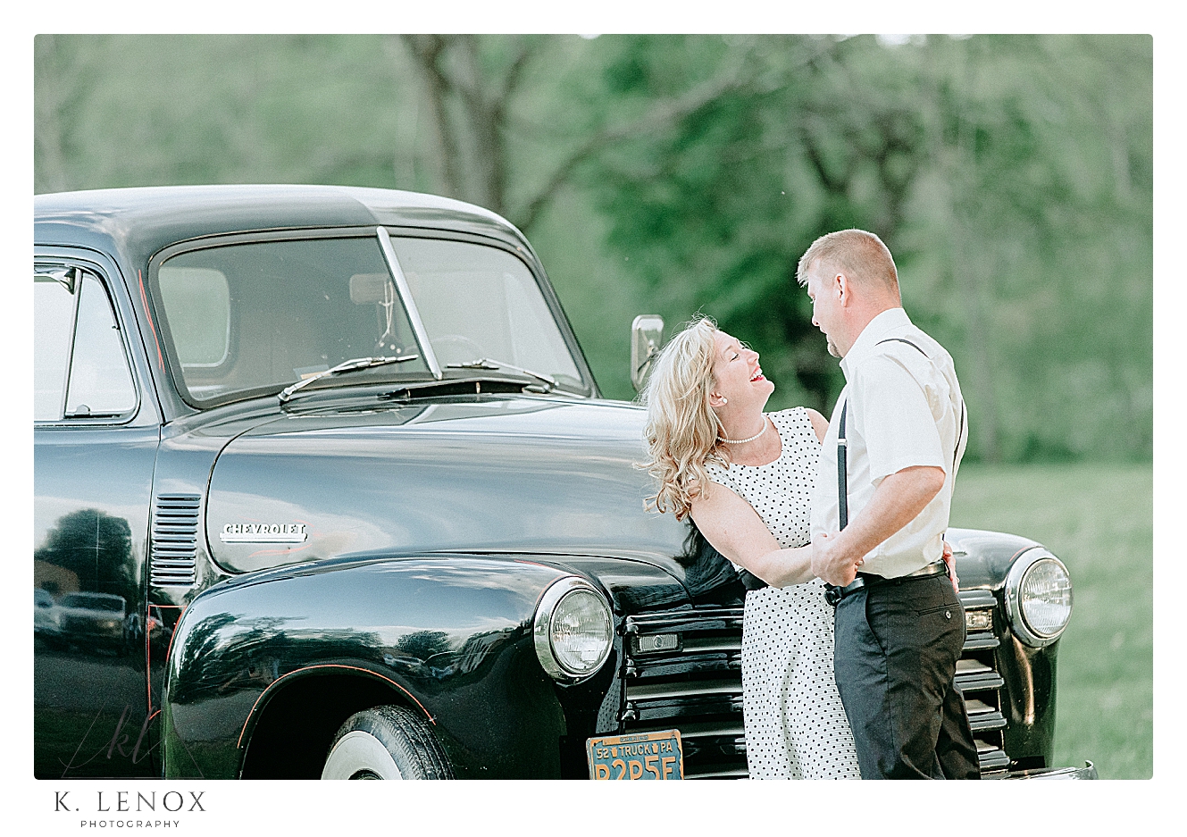 Light and Airy Photo of a couple posing in front of a 1957 Chevy Truck for their engagement session.