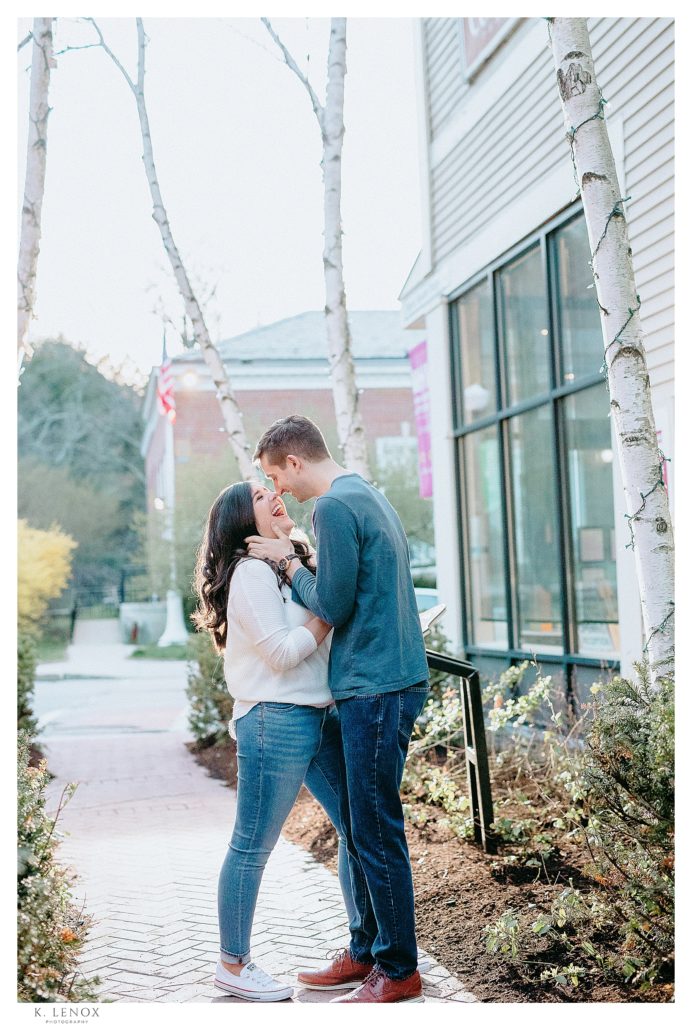 fun, light and airy photo of a man and woman looking at each other laughing and smiling during their spring engagement session with K. Lenox Photography