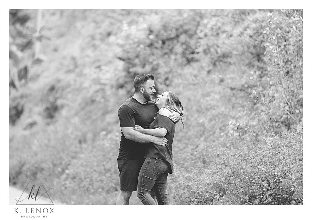 Candid photo of a man and woman laughing during their relaxed engagement session in Brattleboro with K. Lenox Photography. 