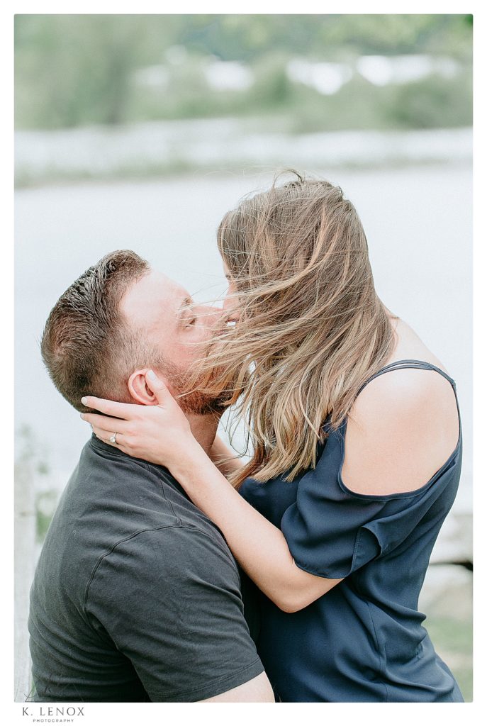 Relaxed Engagement session in Brattleboro VT with a Man and Woman kissing while the wind blows her hair. 