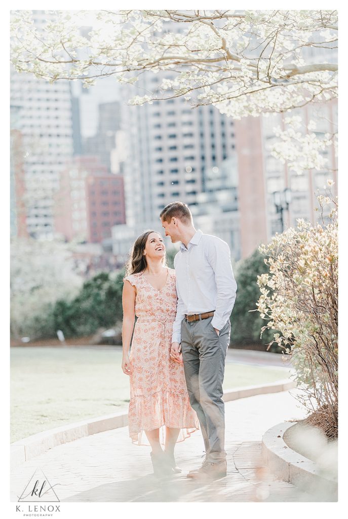 Man and Woman hold hands during their light and airy spring engagement session in Boston. 