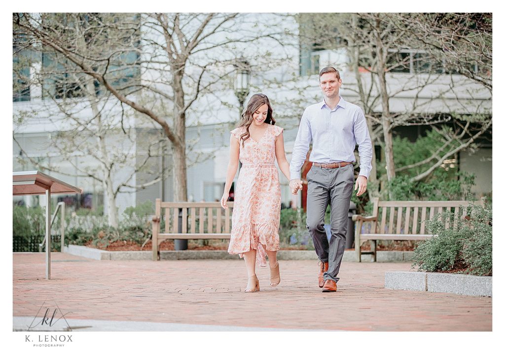 Man and Woman walking in Boston at the Seaport during their Spring Engagement Session with K. Lenox Photography