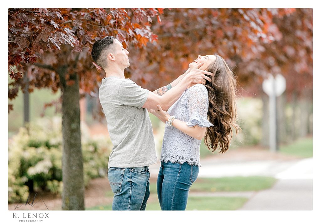 Playful couple laughing during their spring engagement session in Keene NH. 