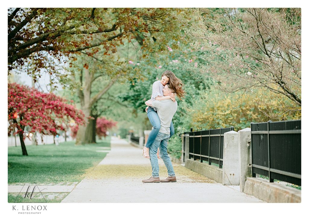 Man and Woman twirl and flirt during their spring engagement session in Keene NH. 