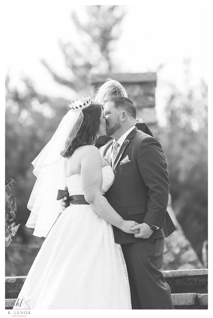 Black and White photo of a Bride and Grooms first kiss on their wedding day- during the ceremony. 