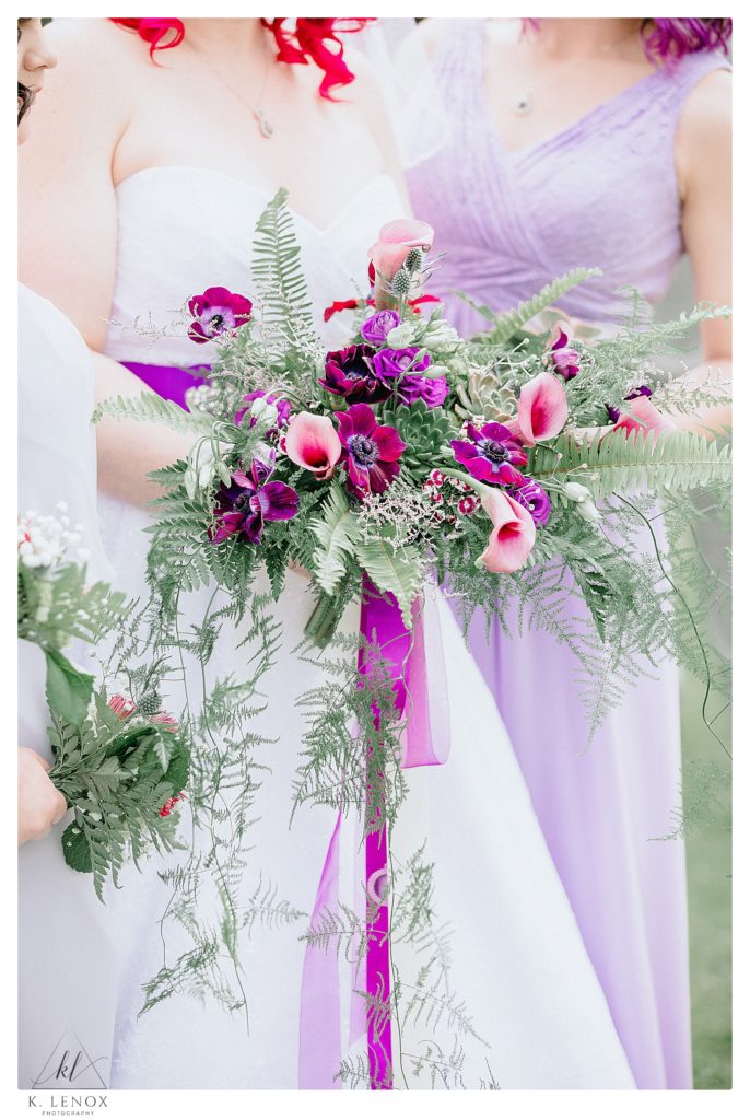 Bridal bouquet with succulents, and various purple flowers, including Cala lilies. 