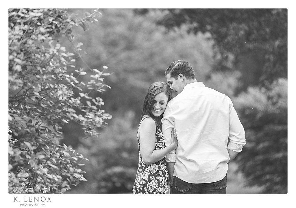 black and white candid photo of an engaged couple in Benson Park in NH.  Photo by K. Lenox Photography