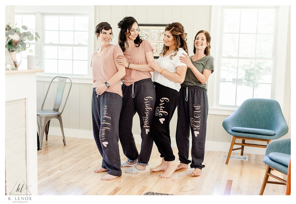 Bride and Bridesmaids wearing matching gray sweatpants that are personalized. 