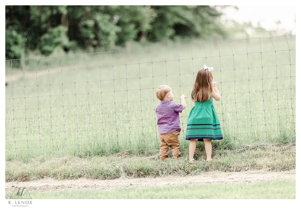 Two young children looking out onto the pasture during a wedding reception at Mayfair farm. 