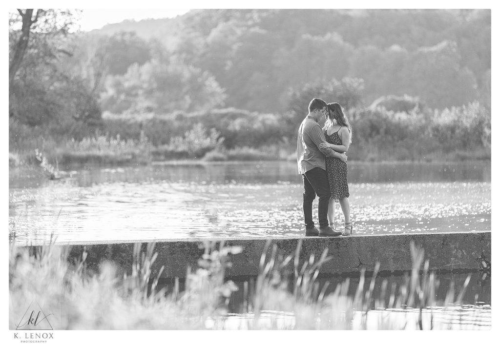 Black and White photo of a man and woman hugging during their Outdoor Engagement Session in Brattleboro VT- Riverside. 