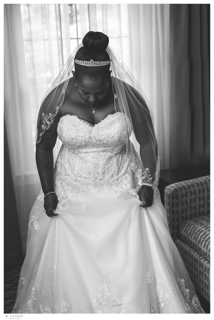 Black and white photo of a bride on her wedding day wearing a veil and dress. 