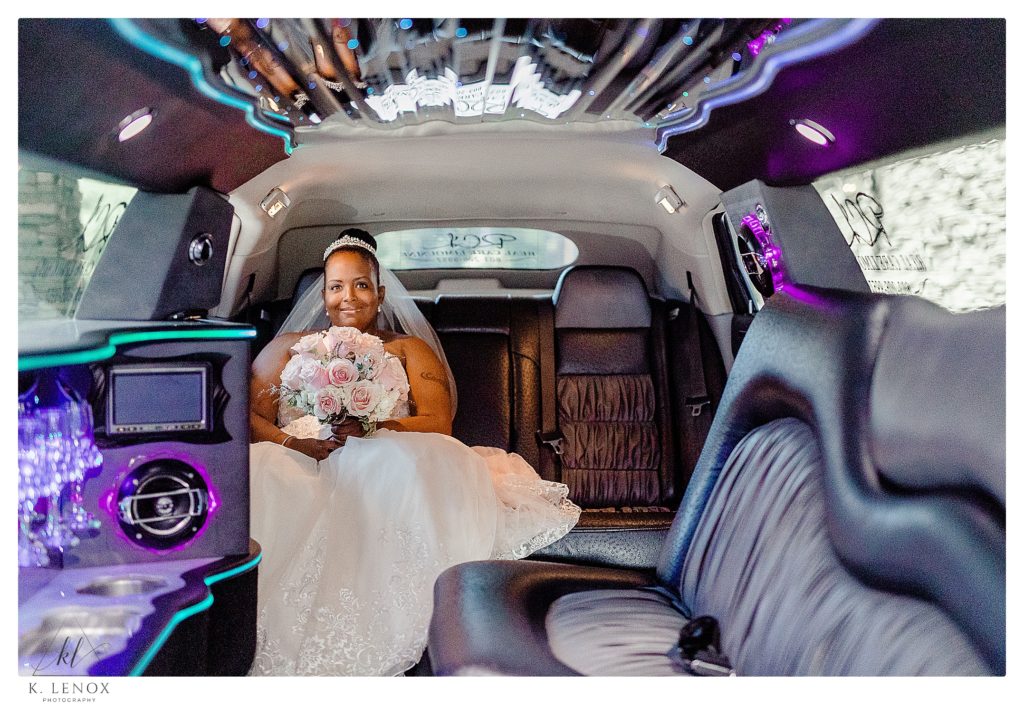 Bride sitting in a limo holding her bouquet. 