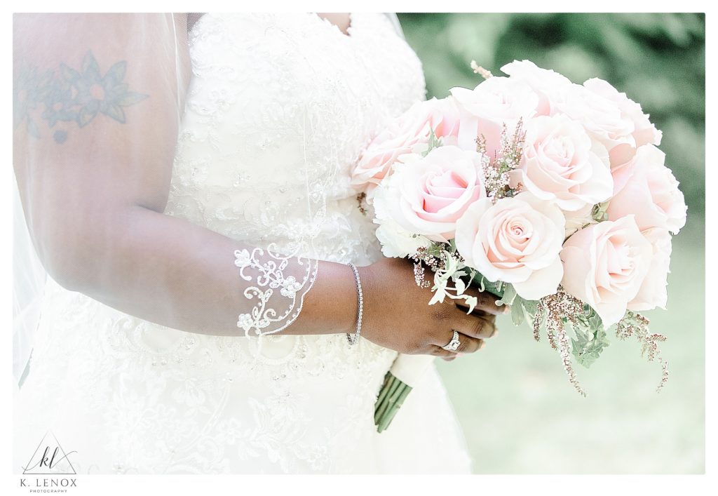 Detail shot showing a Light Pink Rose Bridal bouquet being held by the bride. 