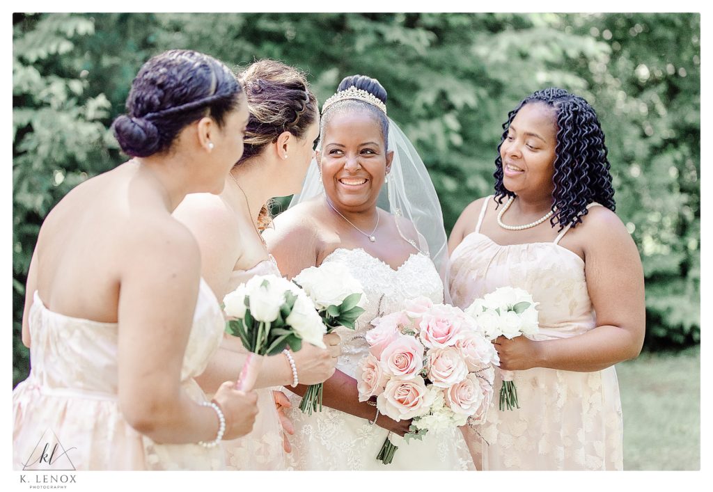 Light and Airy photo showing a bride and her bridesmaids in a candid nature, laughing. 