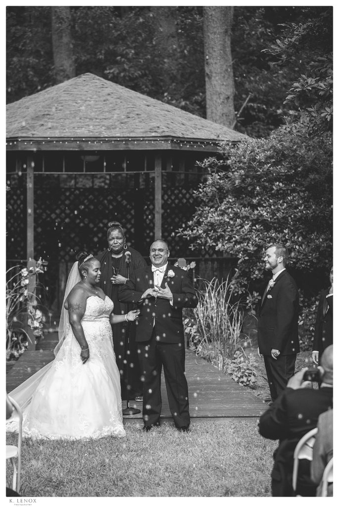 Classic wedding at Alpine Grove in Hollis NH.  Black and white photo of a bride and groom immediately after they were married in front of the gazebo.  Bubbles being blown too.