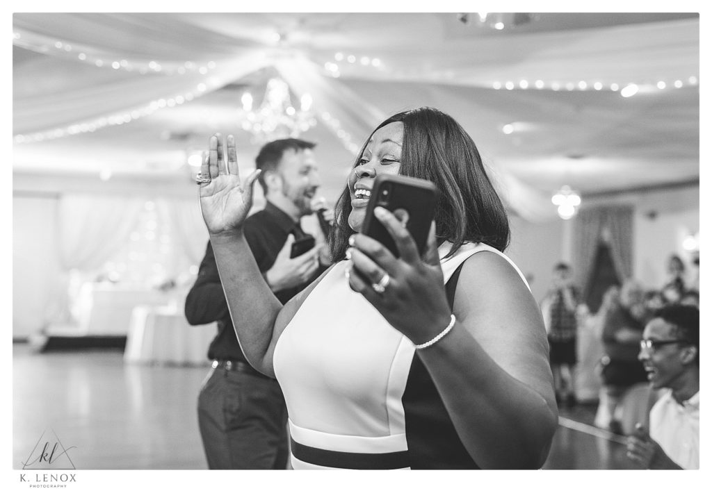 Candid black and white photo of a woman laughing during a classic wedding reception at Alpine Grove Banquet Facility in Hollis NH. 