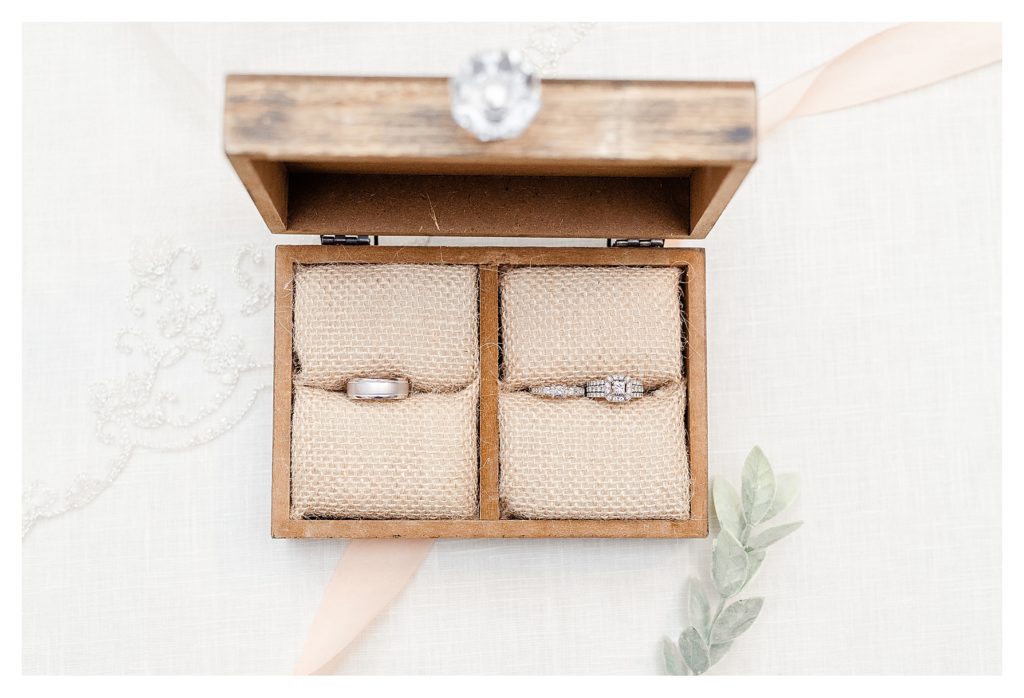 Dual wooden ring box showing the bride and grooms wedding rings in White gold. 