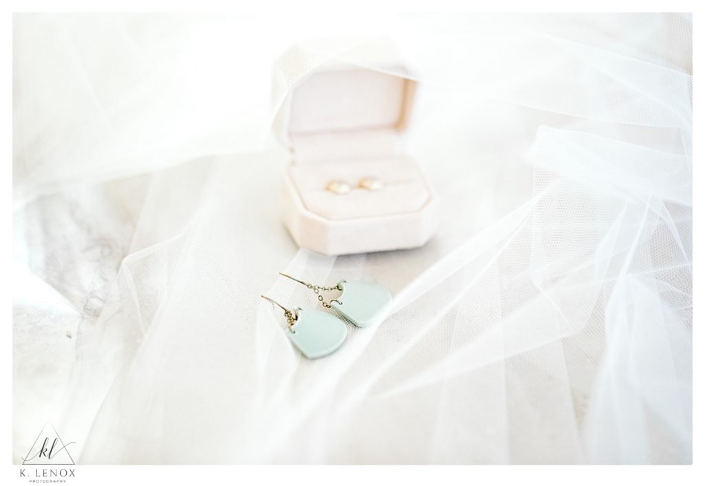 Light and Airy photo showing custom designed teal earrings on a brides veil. 