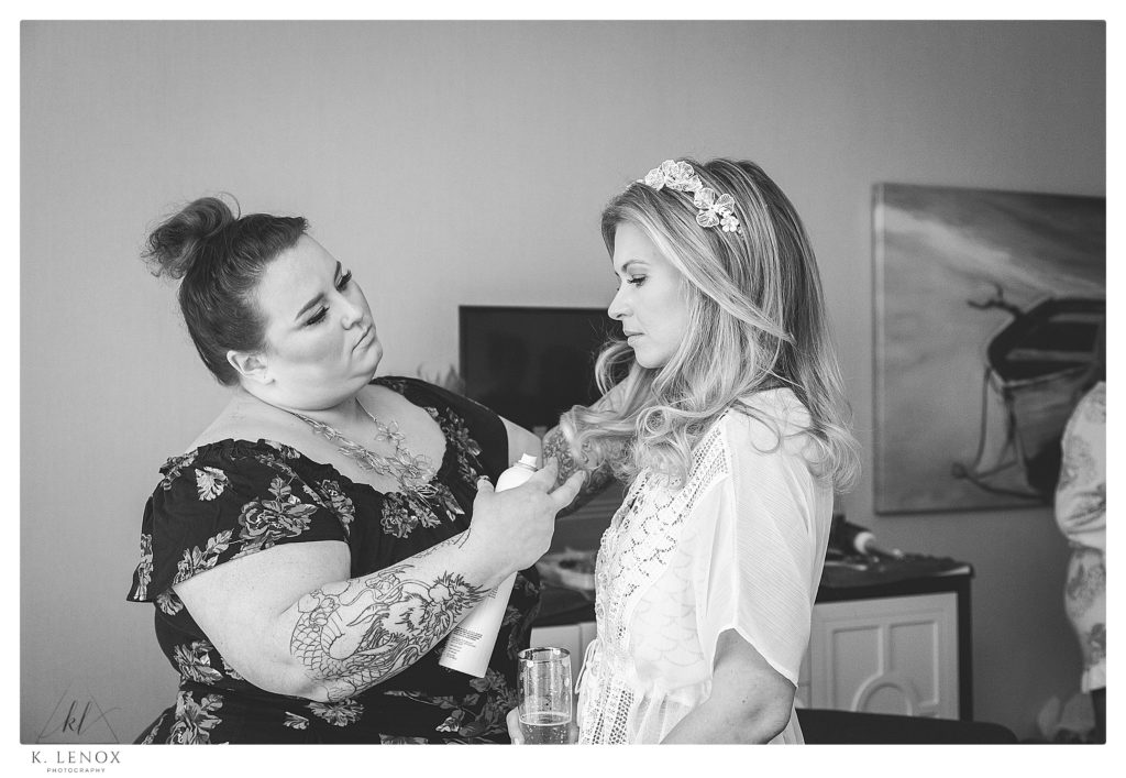 Black and White photo of a bride getting her hair fixed by the hairstylist. 