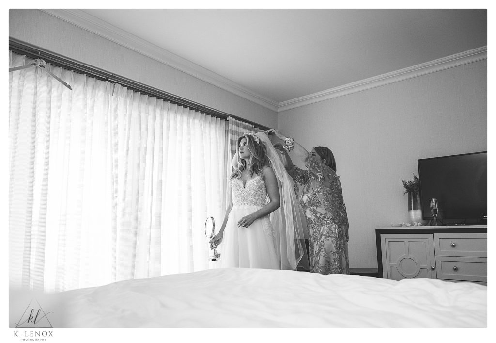 Black and White candid photo of a bride getting her veil on by her mother in the Bridal Suite at the Wentworth by the sea. 