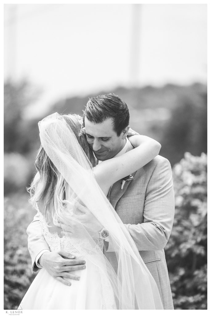 Black and white photo of a bride and groom hugging. 