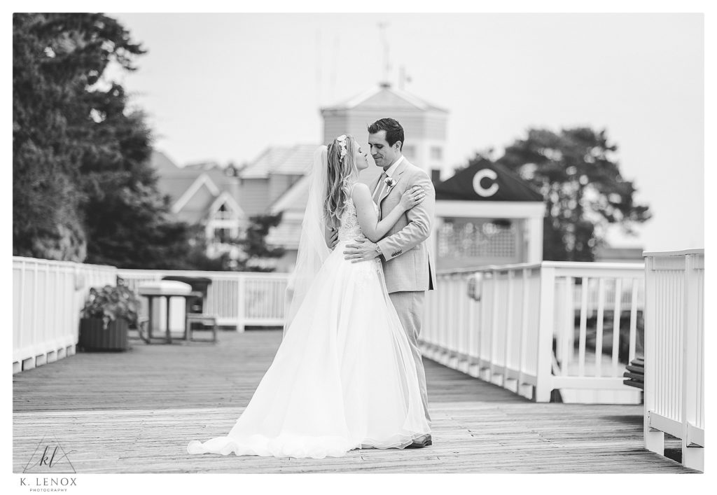 Black and white photo of a bride and groom on the boardwalk in front of the Wentworth by the sea. 