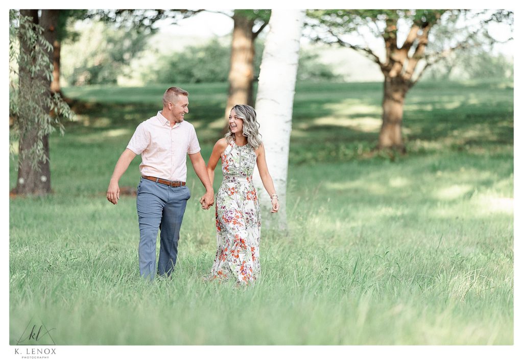 Man and Woman holding hands during their Light and Airy Engagement session at Alyson's Orchard