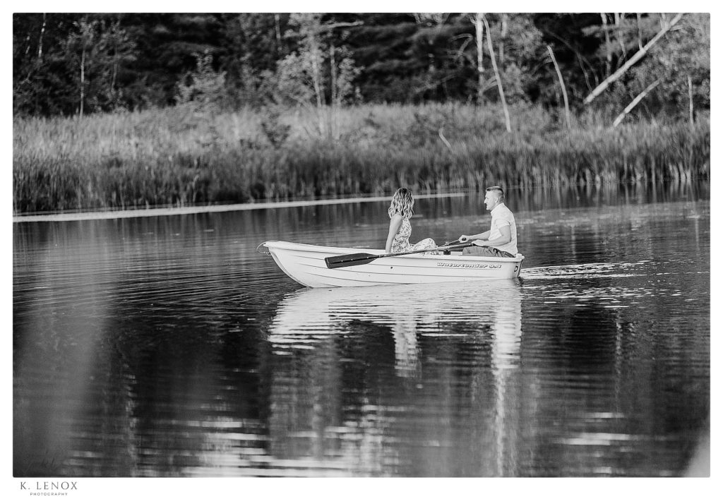 Candid black and white photo of an engaged couple in a Row boat at Alyson's Orchard in Walpole NH. 