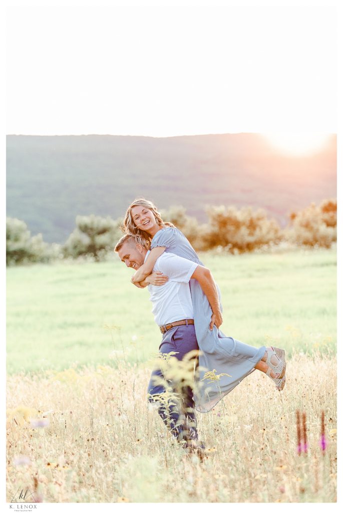 Light and Airy engagement session at Alyson's Orchard showing a man carrying his fiance on his back. 