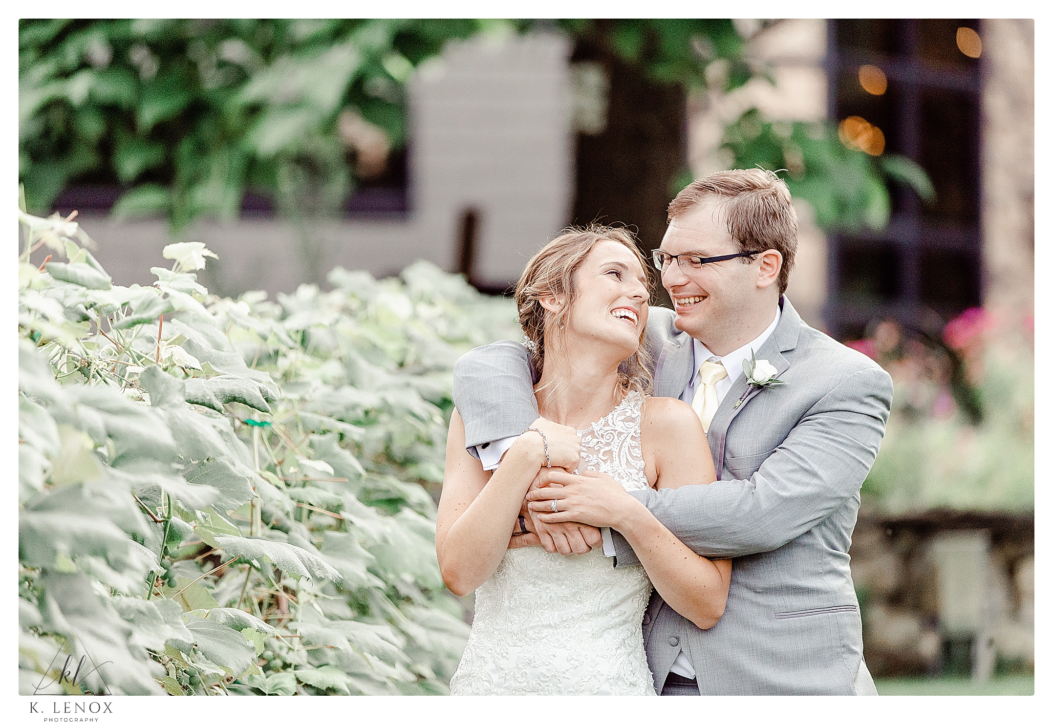 Husband and Wife laugh together while at their Summer Wedding at Birch Wood Vineyard