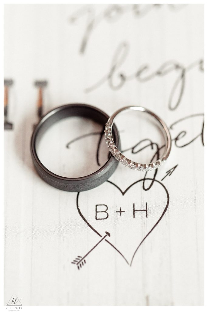 Two Wedding bands (His and hers) shown on a wedding invitation showing the initials "B and H"