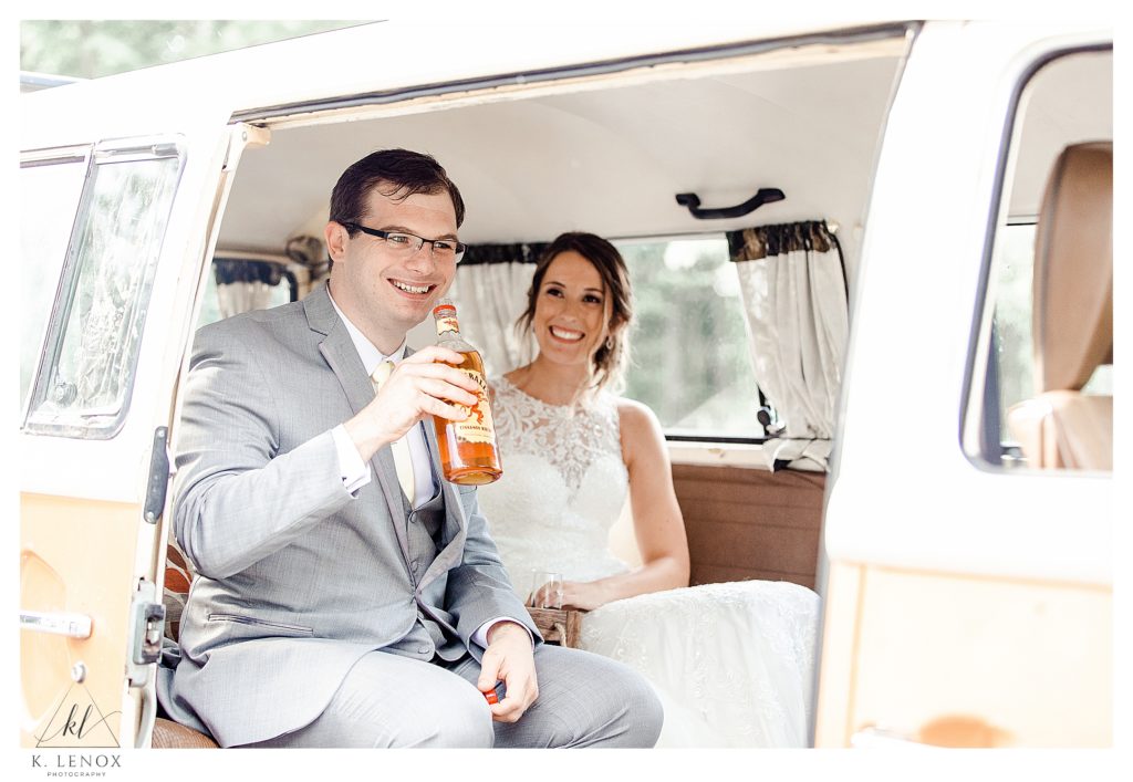 Bride and Groom sitting inside a 1978 VW Bus having a shot of Fireball. 