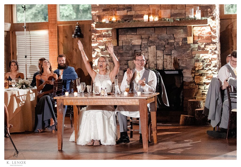 Couple laugh and clap during the speech their Summer Wedding Reception at the Birch Wood Vineyard in Bedford NH.